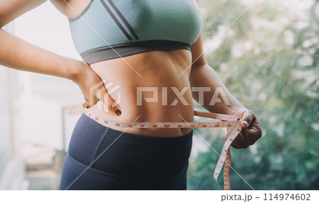 fat woman, fat belly, chubby, obese woman hand holding excessive belly fat with measure tape, woman diet lifestyle concept 114974602