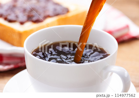 朝食の食卓のコーヒーカップにコーヒーを入れる 朝食の食卓のコーヒーカップにコーヒーを入れる 114977562