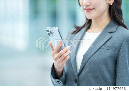 スマホを操作するビジネスパーソン（パーツモデル） 114977668