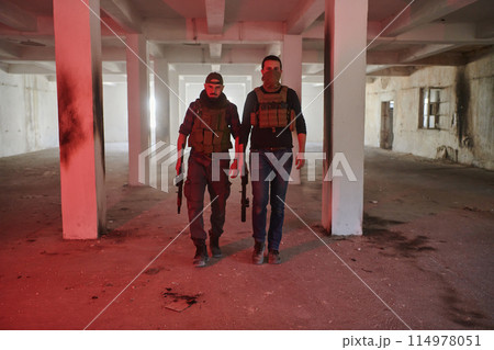An abandoned building serves as the stronghold for a team of terrorists, fiercely guarding their occupied territory with guns and military equipment 114978051