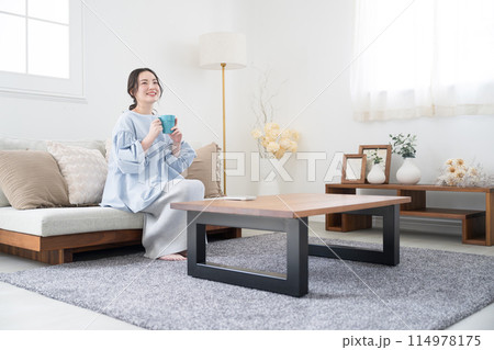 コーヒーや飲み物を持ってリビングでくつろぐ女性 114978175