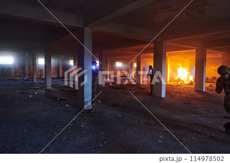 A group of professional soldiers bravely executes a dangerous rescue mission, surrounded by fire in a perilous building. A group of professional soldiers bravely executes a dangerous rescue mission, surrounded by fire in a perilous building. 114978502