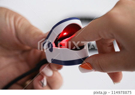 Close up photo of oxygen pressure measurement. Female hands of a doctor and patient. Doctor uses a pulse oximeter to measure the patient's pulse and oxygen level Close up photo of oxygen pressure measurement. Female hands of a doctor and patient. Doctor uses a pulse oximeter to measure the patient's pulse and oxygen level 114978875