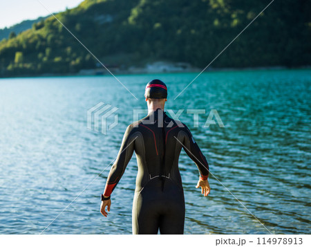 A triathlon swimmer preparing for a river training to gear up for a marathon 114978913