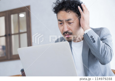 円安、株安、投資などのミス(失敗)で頭を抱える男性 114979288