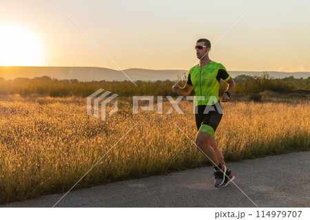 Triathlete in professional gear running early in the morning, preparing for a marathon, dedication to sport and readiness to take on the challenges of a marathon.  114979707