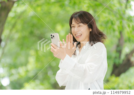 スマートフォンを操作するミドル女性 114979952
