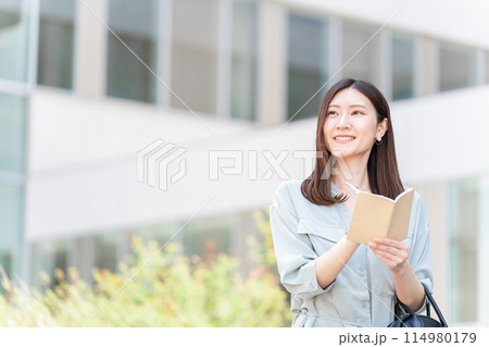 手帳・日記・メモ帳・ノート・スケジュール帳・予定帳に記入する女性・ビジネスウーマン 114980179