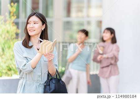 手帳・日記・メモ帳・ノート・スケジュール帳・予定帳に記入する女性・ビジネスウーマン 114980184