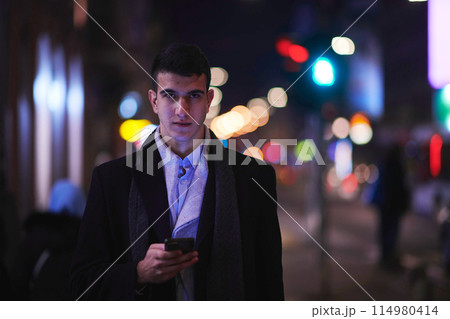 Smiling Meedle Eastern man walking down street near modern office building, 114980414
