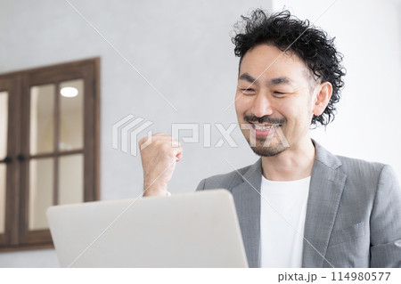 パソコンを見てガッツポーズをする男性 仕事や投資などの成功のイメージ パソコンを見てガッツポーズをする男性 仕事や投資などの成功のイメージ 114980577