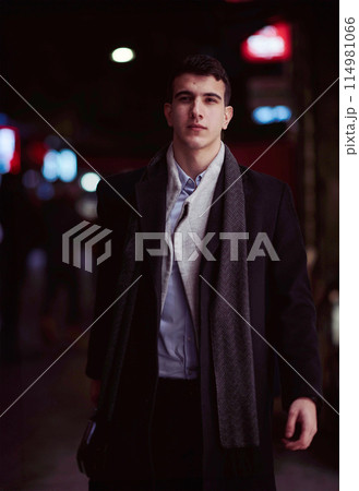 Smiling Meedle Eastern man walking down street near modern office building, 114981066