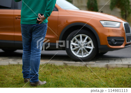 man taking photos on a smartphone of a car preparing for sale  114981113