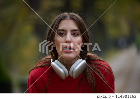 Athletic young woman taking a breath and relaxing after jogging and stretching. Woman Training and Workout Exercises On Street. 114981162