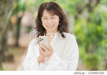スマートフォンを操作するミドル女性 114981583