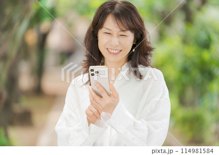 スマートフォンを操作するミドル女性 スマートフォンを操作するミドル女性 114981584
