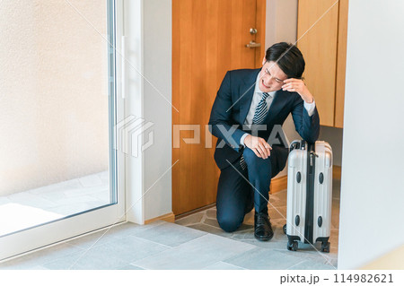 出張から帰宅した疲れたサラリーマン・ビジネスマン（激務・過労・ハードワーク・ストレス・多忙） 114982621