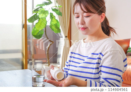 くすりを飲む女性 114984561