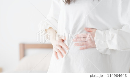 ぽっこりお腹を気にする女性 ぽっこりお腹を気にする女性 114984648