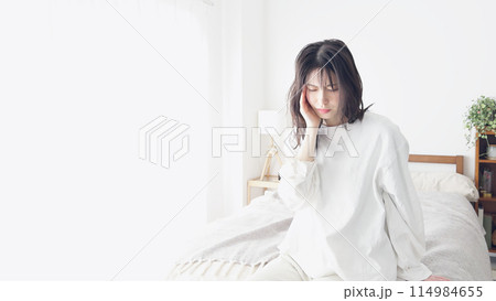 痛む顎を押さえる女性 痛む顎を押さえる女性 114984655