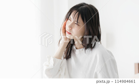 痛む顎を押さえる女性 痛む顎を押さえる女性 114984661
