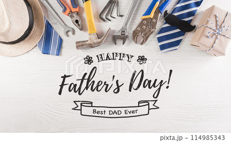 Happy Father's Day decoration with beautiful tie with mustache, hand tools, glasses, gift box and hat on white wooden background. Happy Father's Day decoration with beautiful tie with mustache, hand tools, glasses, gift box and hat on white wooden background. 114985343