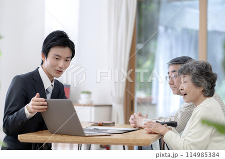 シニア夫婦と話す訪問営業の男性 114985384