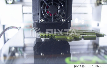 3D printer working close-up. 3D printer prints model from molten plastic close-up. 3D printer printing object. Additive progressive high-tech technology. New modern prototyping technologies. 114986396
