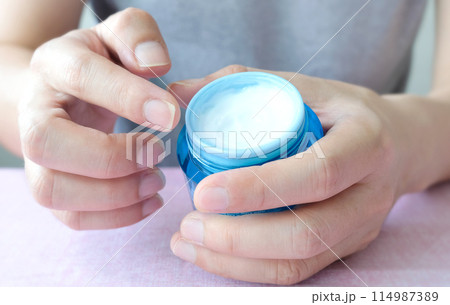 Hand of woman holding moisturizer cream and serum. Beauty and Healthy Concept. Hand of woman holding moisturizer cream and serum. Beauty and Healthy Concept. 114987389