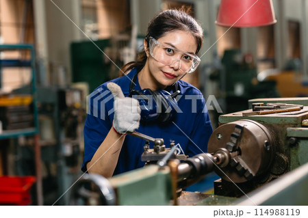 Portrait engineer worker thumbs up professional working in metal lathe milling machine heavy industry factory. 114988119