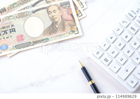 福沢諭吉の肖像の一万円紙幣と電卓 114989629
