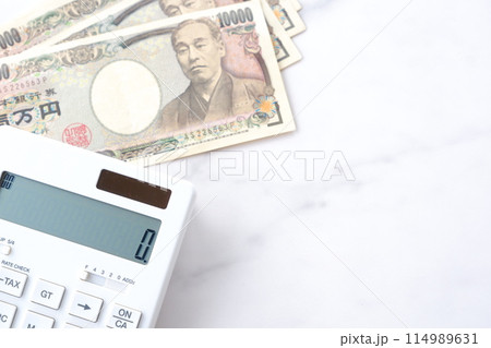 福沢諭吉の肖像の一万円紙幣と電卓 114989631