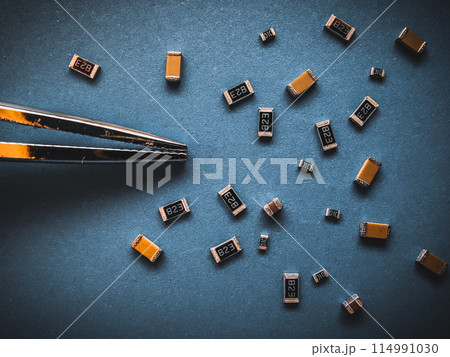 Electronic components, many ceramic capacitors and chip resistors on PCB background Electronic components, many ceramic capacitors and chip resistors on PCB background 114991030