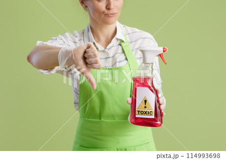Unhappy woman showing thumbs down isolated on green 114993698