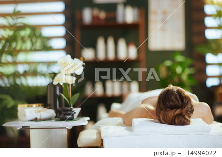 relaxed modern female in spa salon laying on massage table relaxed modern female in spa salon laying on massage table 114994022