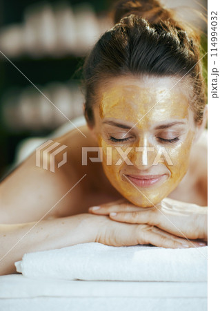 relaxed modern female in spa salon laying on massage table 114994032