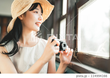 車窓から写真を撮る女性 114994166