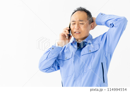 作業服の男性　スマホ　通話　困る 114994554
