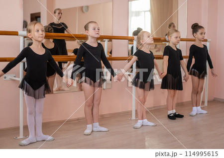 Children's ballet school. Caucasian woman teaching ballet to little girls.  114995615