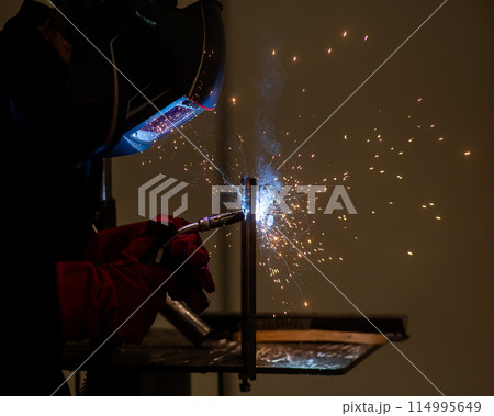 A man learns the craft of welding on a sample. A man learns the craft of welding on a sample. 114995649