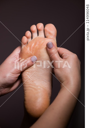 Close-up of a woman's foot massage. Vertical photo. Close-up of a woman's foot massage. Vertical photo. 114996048