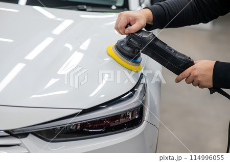 Process of polishing white car hood surface using orbital polishing machine. Process of polishing white car hood surface using orbital polishing machine. 114996055