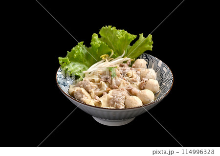 Bowl of delicious pork dumplings soup with meatballs and vegetables isolate black background 114996328