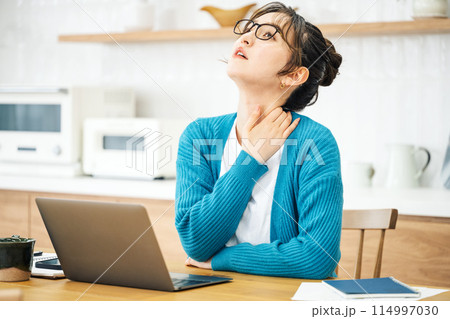 テレワークで肩が凝って悩む女性 114997030