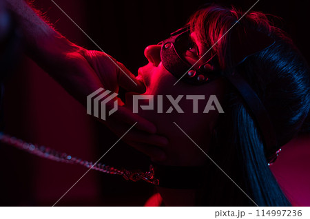 Role-playing games. Man putting finger in woman's mouth in cat mask. Role-playing games. Man putting finger in woman's mouth in cat mask. 114997236