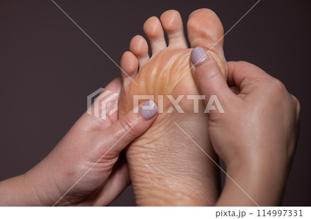 Close-up of a woman's foot massage. Close-up of a woman's foot massage. 114997331