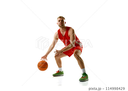 Dynamic portrait of young athlete man, professional basketball player ready to score goal against white studio background. 114998429