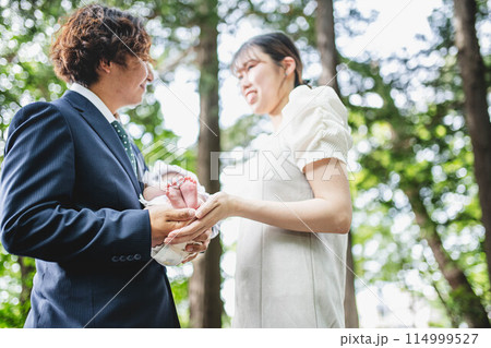 新緑の中でお宮参りする家族 114999527