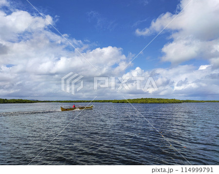 Man on a Motorized Outrigger Boat 114999791