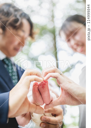 0歳児の息子の足を触る両親 114999844